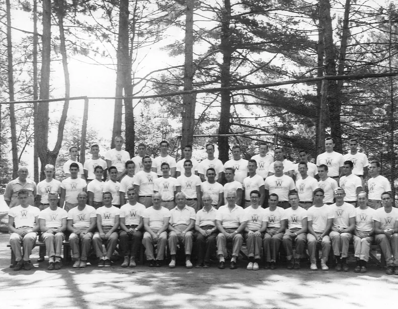 Black and white Camp Wigwam group photo from the 1950s with campers and staff on the lodge steps