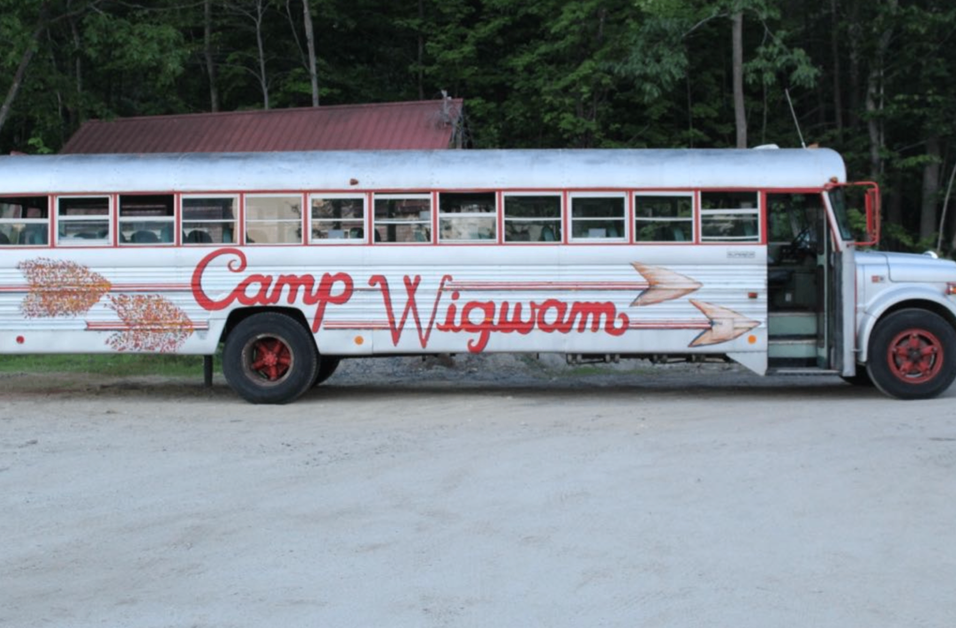 Camp Wigwam chartered bus parked at camp with red script lettering