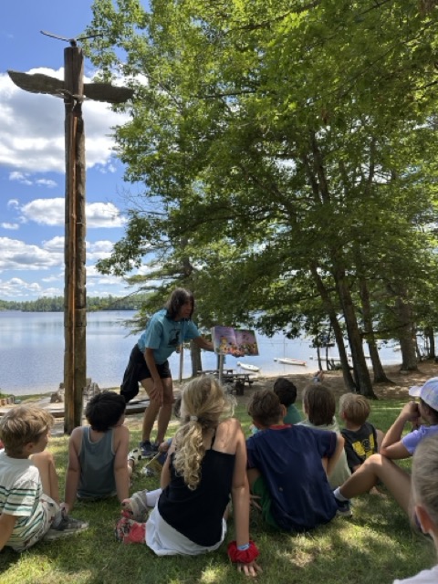Jane reading a picture book to Little Loons on the lakefront lawn